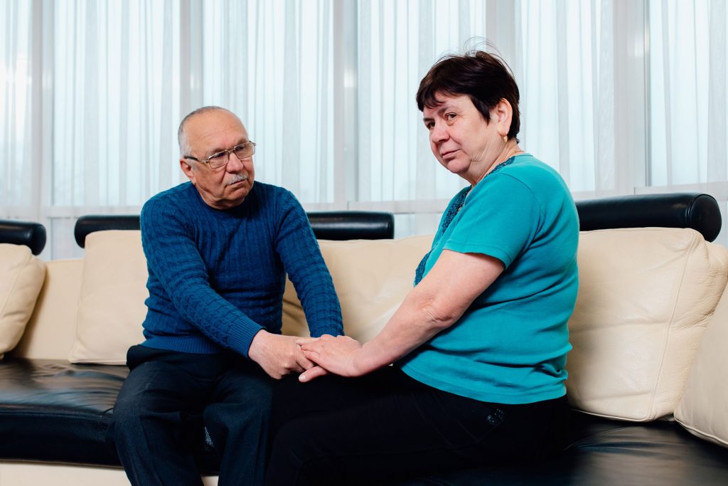 Senior man with parkinson's disease talking to his wife.