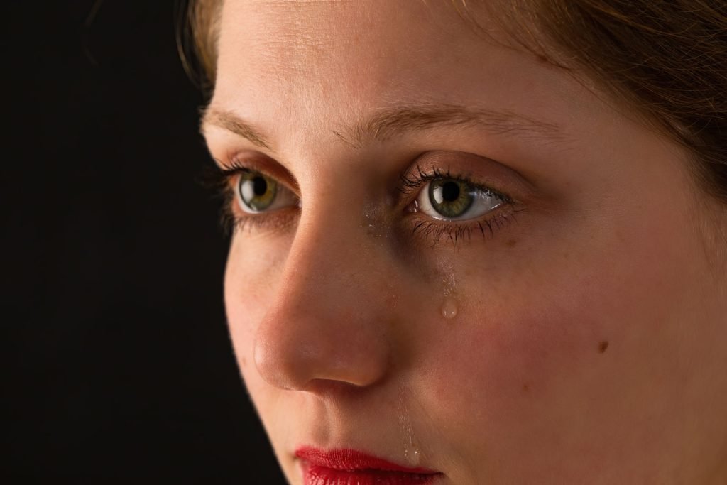 Woman crying in her one eye.